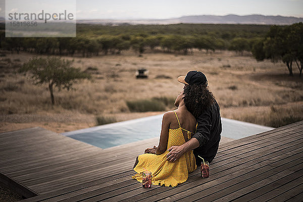 Rückansicht eines Paares  das auf dem Deck einer Lodge sitzt  Kapstadt  Südafrika