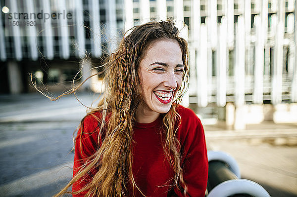 Porträt einer glücklichen jungen Frau in der Stadt