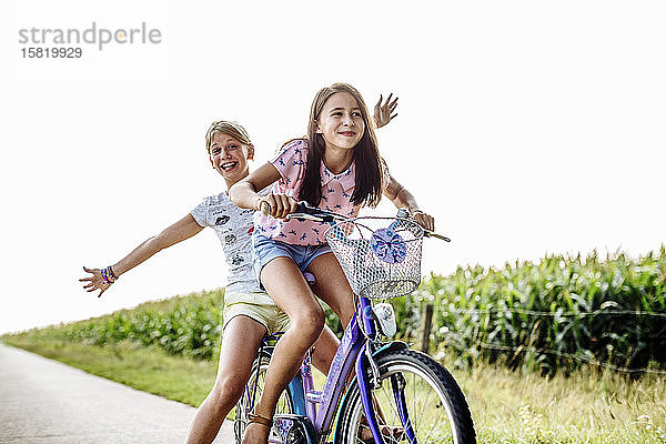 Glückliche Mädchen auf dem Fahrrad auf einem Feldweg