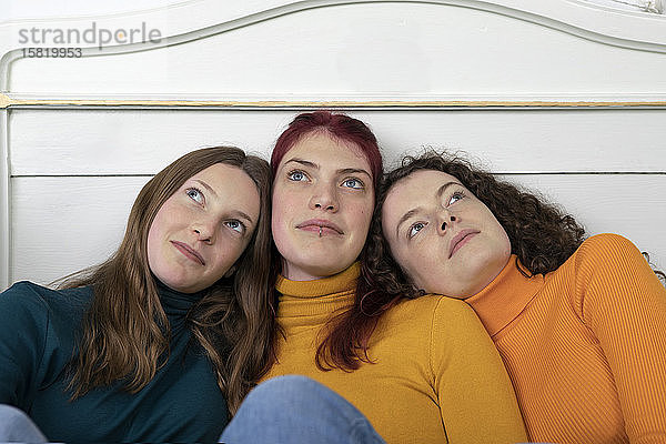 Porträt von drei Schwestern Kopf an Kopf aus der Distanz betrachtet