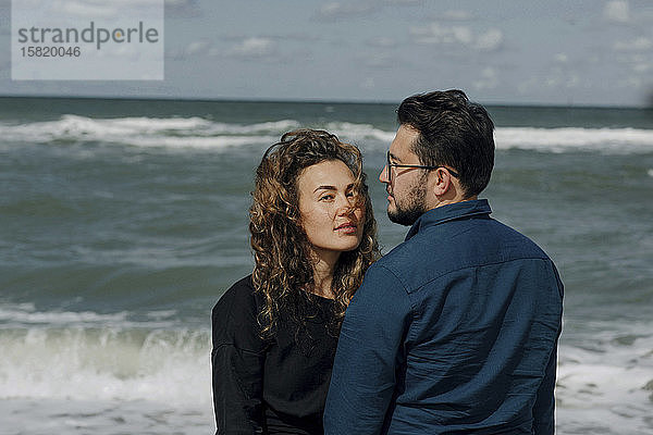 Vor dem Meer stehendes Ehepaar