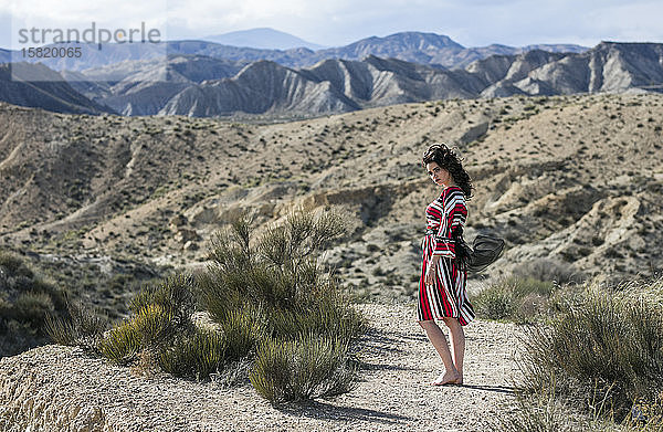 Modische Frau trägt gestreiftes Kleid in Landschaft  Almeria  Spanien