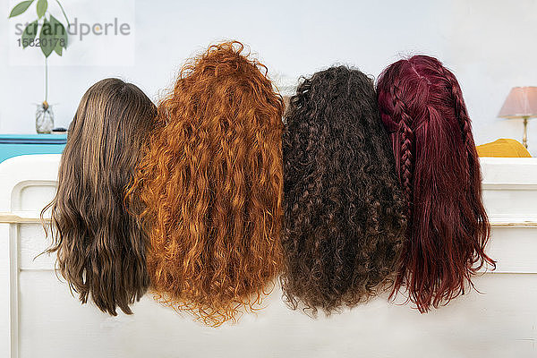 Rückenansicht von vier Frauen mit langen braunen und roten Haaren