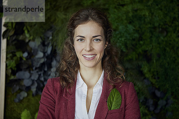 Porträt einer lächelnden Geschäftsfrau im grünen Büro