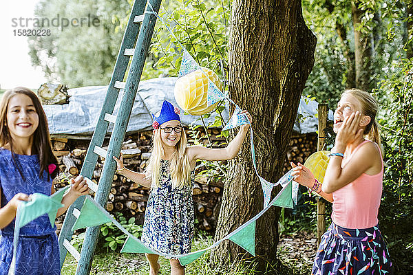 Mädchen dekorieren den Garten für eine Geburtstagsfeier
