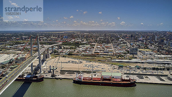 Mosambik  Katembe  Luftaufnahme von zwei Containerschiffen  die unter der Maputo-Katembe-Brücke hindurchfahren  mit der Stadt im Hintergrund