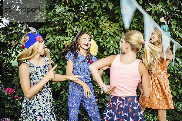 Glückliche Mädchen tanzen auf einer Geburtstagsfeier im Freien