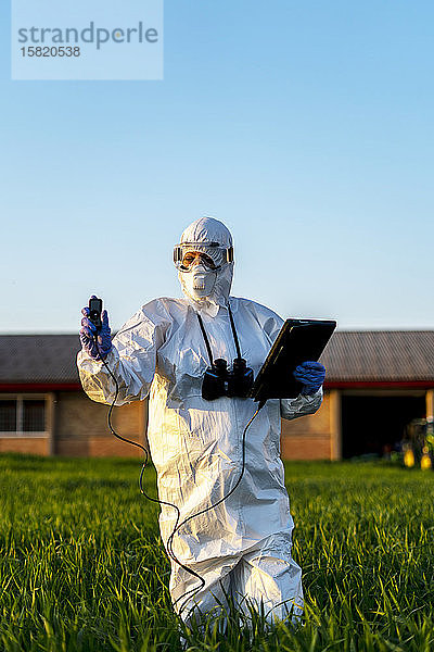 Wissenschaftlerin  die im Feld forscht und Messgeräte benutzt