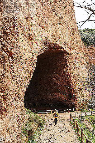 Wanderer am Eingang eines Tunnels  Mina de Oro Romana  ehemalige Goldmine  Las Medulas  Kastilien und León  Spanien