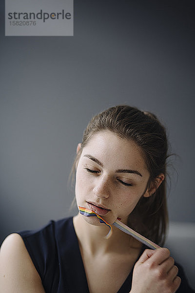Porträt einer jungen Frau  die ein Klebeband von ihrem Mund abzieht