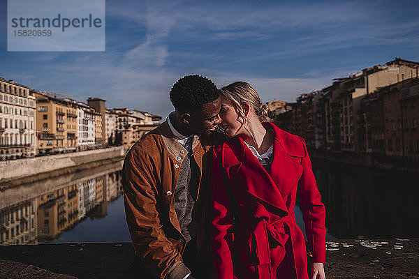 Zärtliches junges Paar küsst sich auf einer Brücke in der Stadt Florenz  Italien