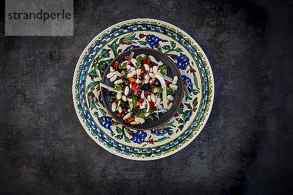 Teller Cannellini-Bohnensalat mit Fenchel  Paprika  schwarzen Oliven  Granatapfelkernen  Minze und Petersilie