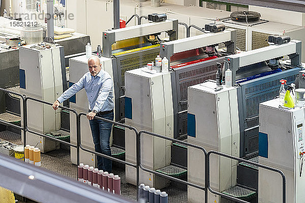 Geschäftsmann  der in einer Druckerei an Maschinen steht