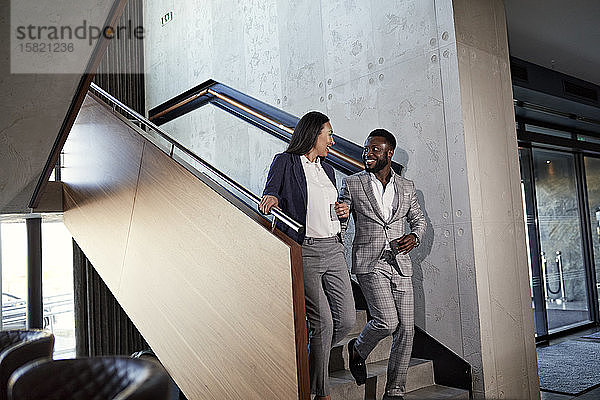 Geschäftsmann und Geschäftsfrau gehen die Treppe hinunter