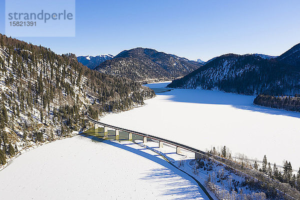 Deutschland  Bayern  Lenggries  Drohnenansicht der Hochstraße  die im Winter den Sylvenstein-Stausee kreuzt