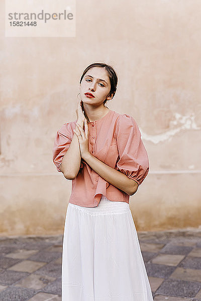 Porträt einer Teenagerin in rosa Bluse und weißem Hosenrock