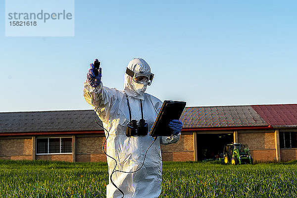 Wissenschaftlerin  die im Feld forscht und Messgeräte benutzt