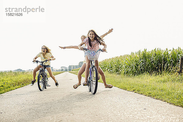 Glückliche Mädchen auf dem Fahrrad auf einem Feldweg