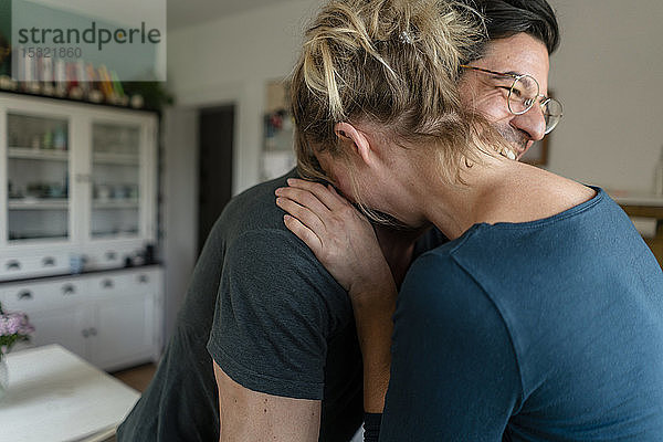 Glückliches Paar umarmt sich zu Hause in der Küche