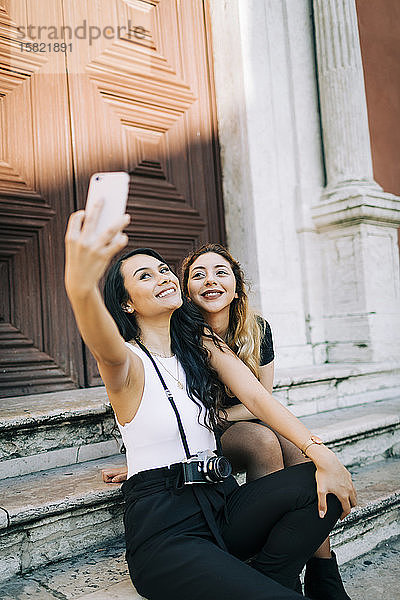 Porträt von zwei jungen Frauen  die sich mit einem Smartphone selbstständig machen  Lissabon  Portugal