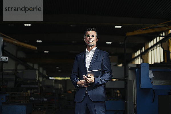 Porträt eines Geschäftsmannes mit Tablette in einer Fabrik