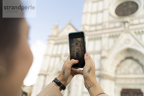 Frau macht ein Smartphone-Foto von der Kirche Santa Croce  Florenz  Italien