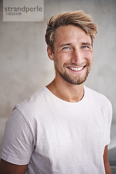 Porträt eines glücklichen jungen Mannes mit weißem T-Shirt
