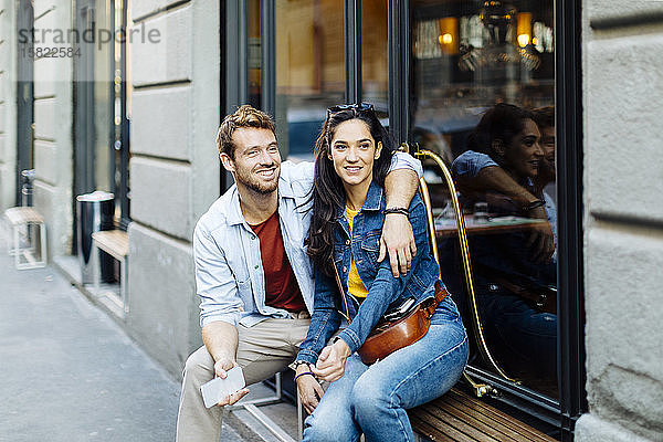 Glückliches junges Paar sitzt auf der Fensterbank in der Stadt  Mailand  Italien