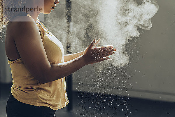 Athletische Frau  die sich auf das Training im Fitnessstudio vorbereitet