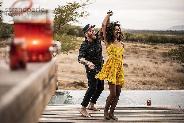 Glückliches Paar tanzt auf dem Deck einer Lodge  Kapstadt  Südafrika