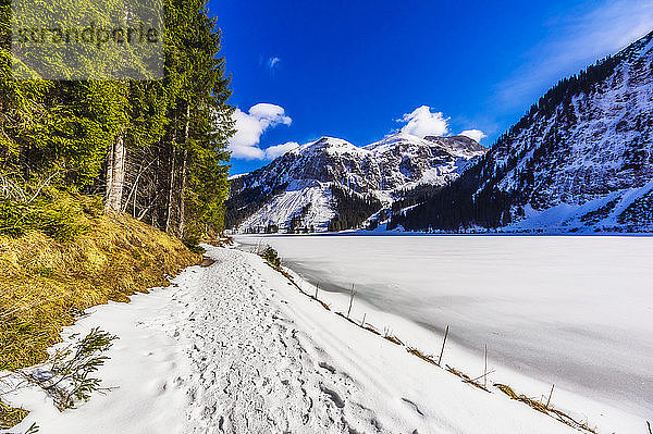 Österreich  Tirol  Tannheim  verschneiter Wanderweg entlang des Ufers des gefrorenen Vilsalpsees