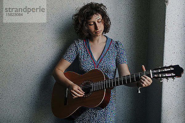 Porträt einer jungen Frau  die Gitarre spielt