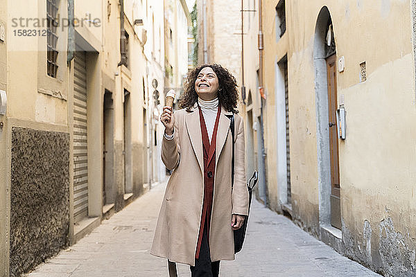 Glückliche Frau isst eine Eistüte in einer Gasse  Florenz  Italien