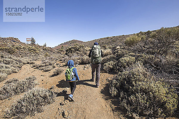 Ein Vater und sein Sohn beim Trekking in der Gegend von Arenas Negras  Teide-Nationalpark  Teneriffa  Spanien