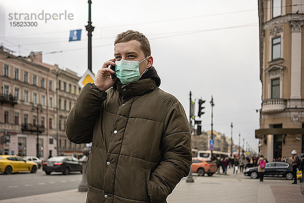 Junger Mann mit Gesichtsmaske  pendelt in der Stadt  St. Petersburg  Russland