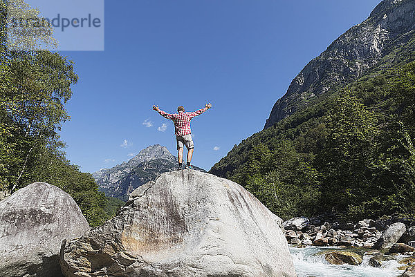 Auf einem Felsen stehender Mann am Fluss Verzasca  Verzascatal  Tessin  Schweiz