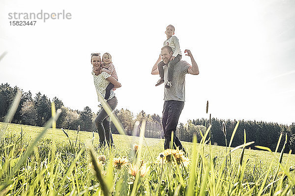 Glückliche Familie mit zwei Kindern im Frühling auf einer Wiese