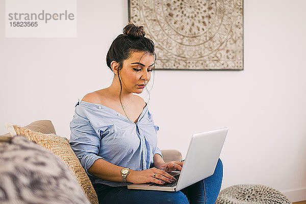 Junge Frau benutzt Laptop zu Hause