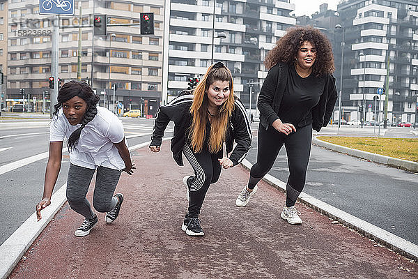 Drei sportliche junge Frauen trainieren in der Stadt