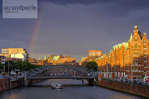 Deutschland  Hamburg  Regenbogen über dem Kanal in der Speicherstadt in der Abenddämmerung