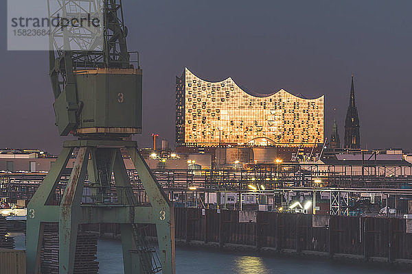 Deutschland  Hamburg  Hafenkran und Elbphilharmonie in der Abenddämmerung