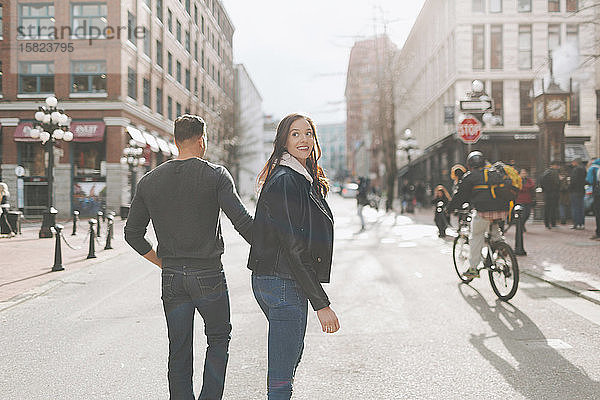 Glückliches Paar geht eine Straße in der Stadt entlang  Vancouver  Kanada