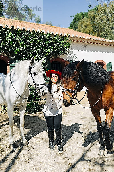 Teenager mit Down-Syndrom trägt roten Hut mit zwei Pferden