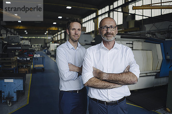 Porträt von zwei selbstbewussten Männern in einer Fabrik