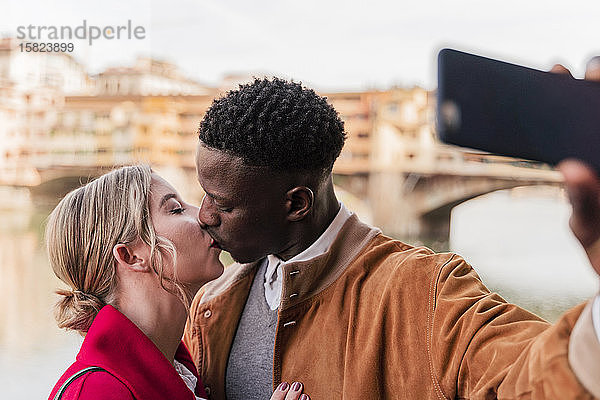 Zärtliches junges Paar küsst sich und nimmt ein Selfie in der Stadt Florenz  Italien