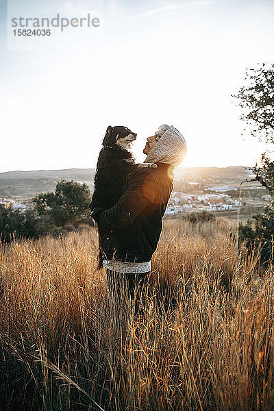 Junger Mann mit seinem Hund bei Sonnenaufgang  Montroy  Spanien