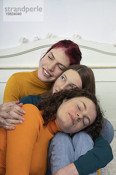 Porträt von drei Schwestern  die sich aneinander kuscheln