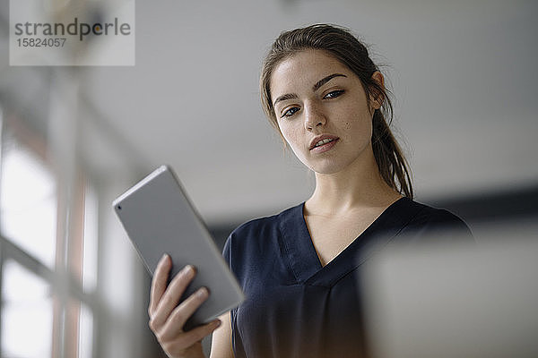 Porträt einer jungen Geschäftsfrau mit digitalem Tablett im Büro