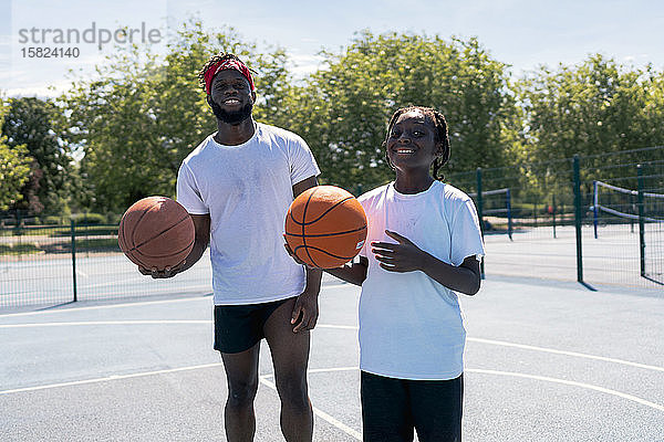 Vater und Sohn mit Basketball auf dem Basketballfeld