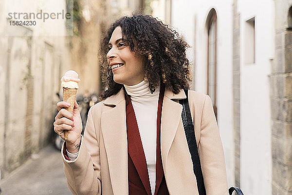 Glückliche Frau isst eine Eistüte in einer Gasse  Florenz  Italien